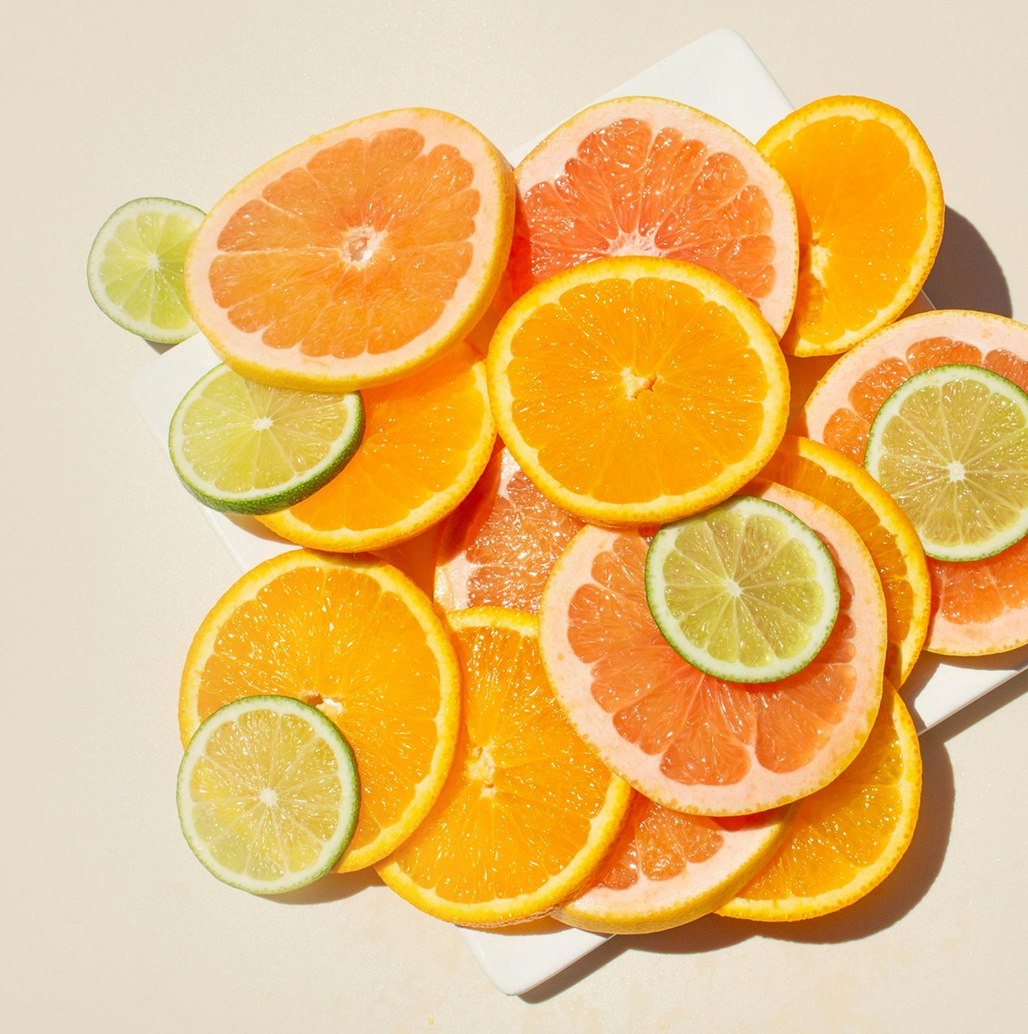 Sliced oranges, grapefruits, and limes on a light background
