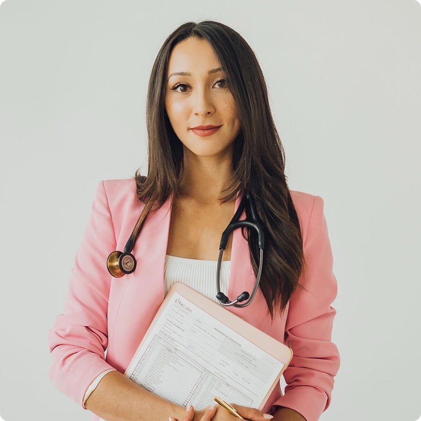 michele in pink blazer with stethoscope and notebook on light gray background